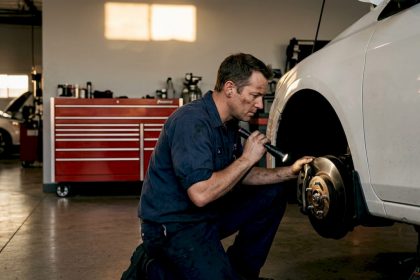 Mechanic inspecting car brakes in garage