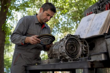 Technician inspecting vehicle transmission parts
