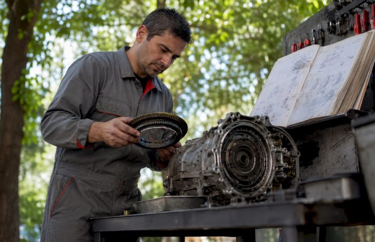 Technician inspecting vehicle transmission parts
