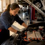 Technician inspecting hybrid vehicle battery