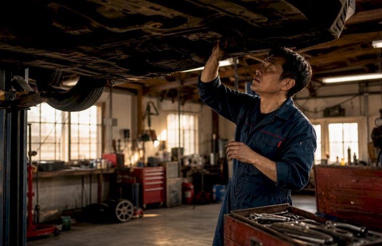 Mechanic inspecting Honda vehicle in garage