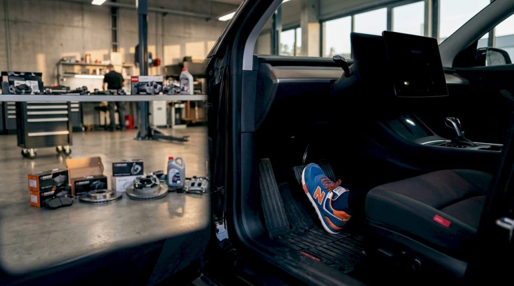 Driver's foot pressing EV brake pedal in workshop