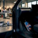 Driver's foot pressing EV brake pedal in workshop
