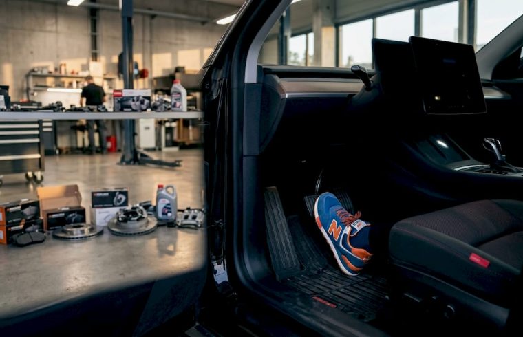 Driver's foot pressing EV brake pedal in workshop