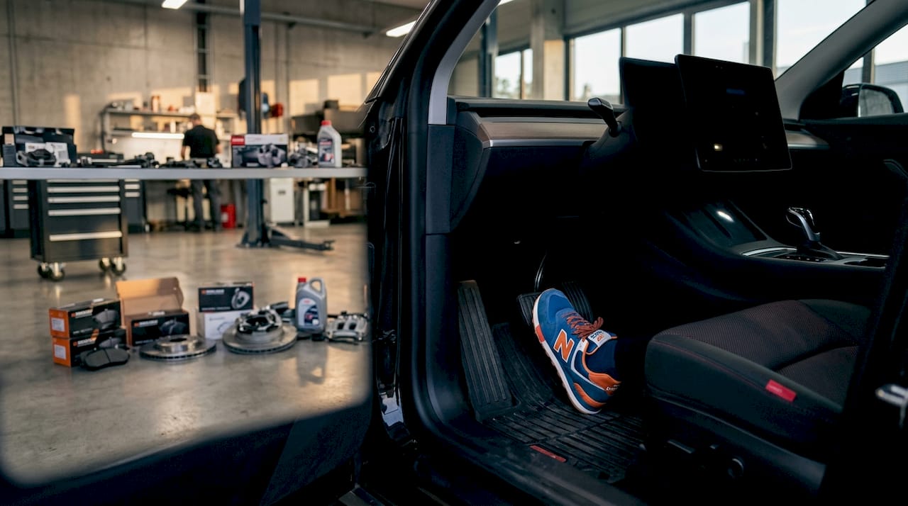 Driver's foot pressing EV brake pedal in workshop