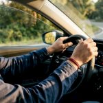 Hands on steering wheel navigating curve