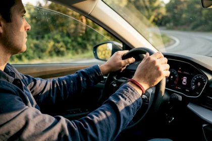 Hands on steering wheel navigating curve