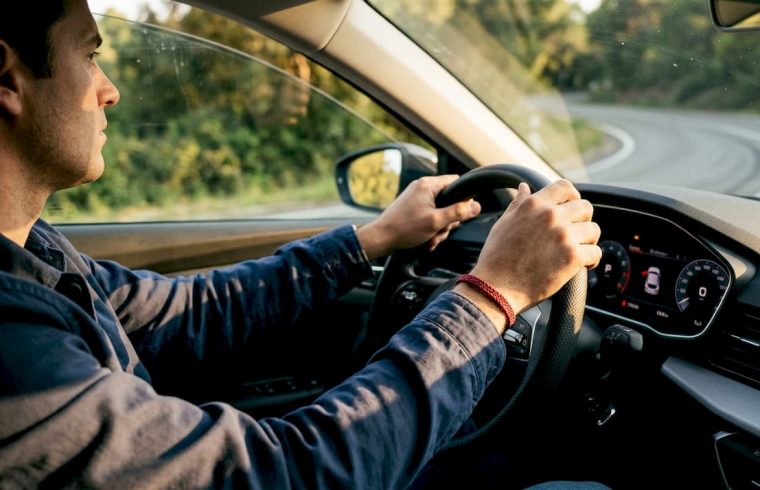 Hands on steering wheel navigating curve