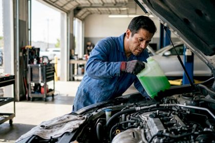 Mechanic inspecting engine coolant reservoir