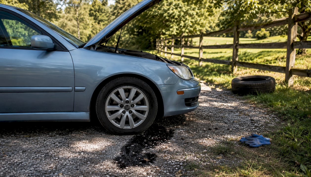 Oil dripping from car engine onto driveway