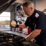 Mechanic checking brake fluid in car engine