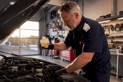 Mechanic checking brake fluid in car engine