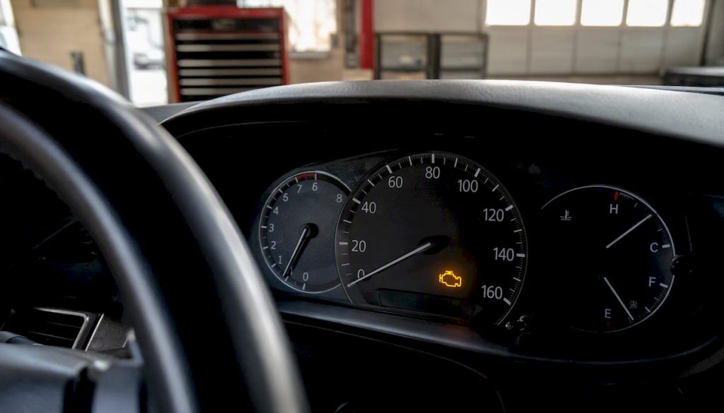 Car dashboard illuminated check engine light