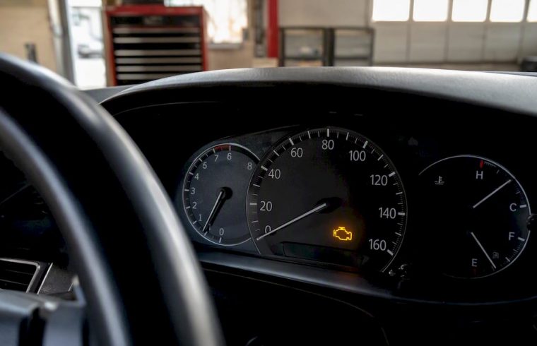 Car dashboard illuminated check engine light