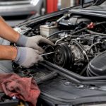 Mechanic inspecting car HVAC system components