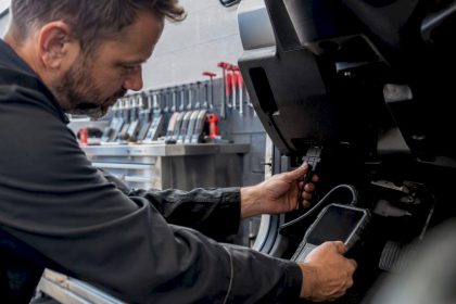 Technician connecting diagnostic scan tool in auto bay
