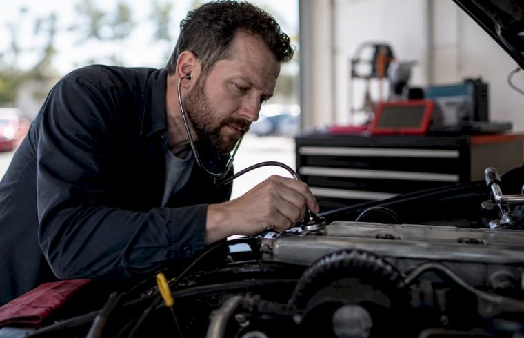 Technician checking engine timing chain noise