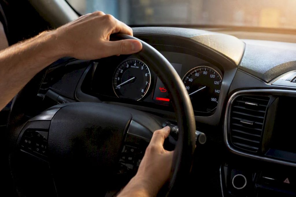 Hands resetting Maintenance Minder on car dashboard