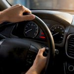 Hands resetting Maintenance Minder on car dashboard