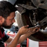 Mechanic inspecting vehicle suspension component
