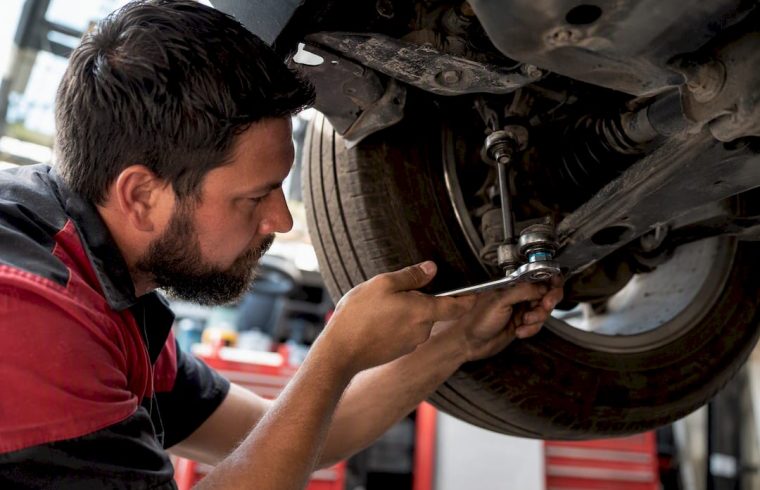 Mechanic inspecting vehicle suspension component