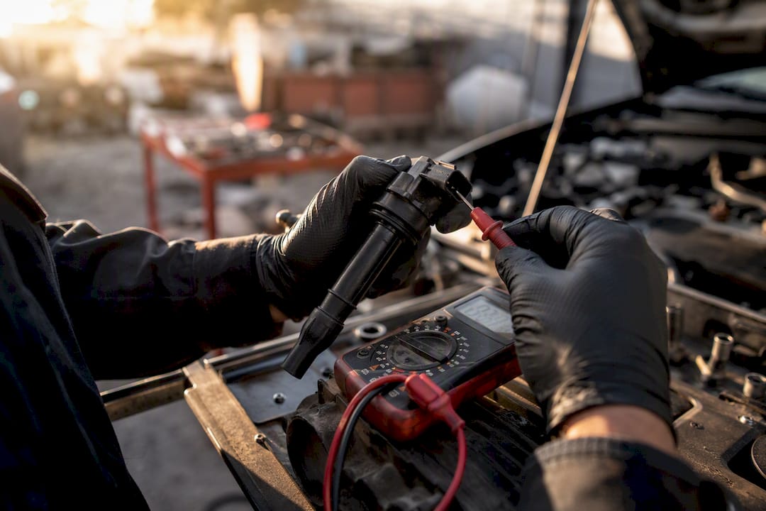 Mechanic hands testing ignition coil in garage
