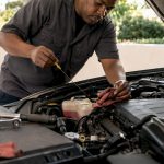 Mechanic checking vehicle fluids under hood