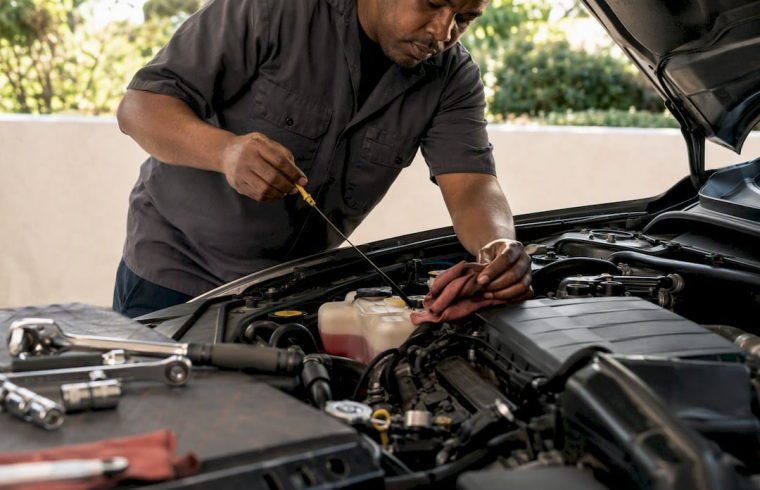Mechanic checking vehicle fluids under hood