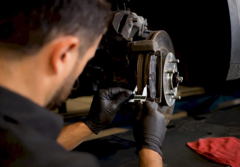 Technician measuring brake pad thickness