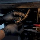 Technician inspecting leaking steering hose connection