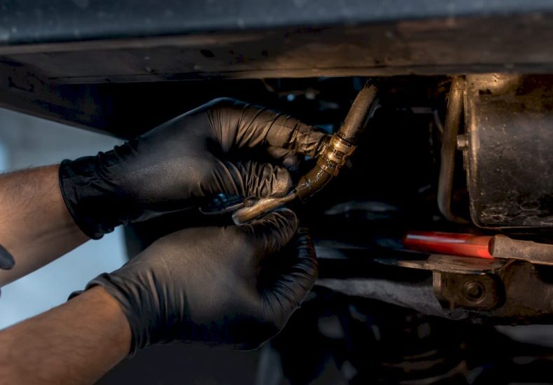 Technician inspecting leaking steering hose connection