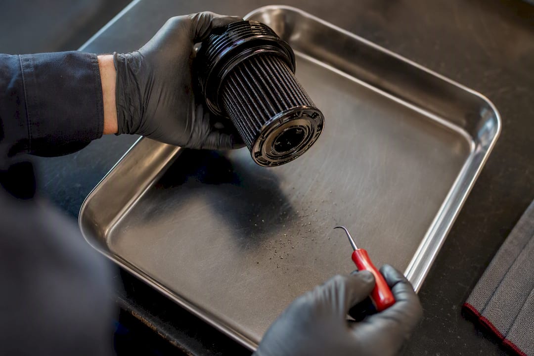 Technician inspecting a removed oil filter