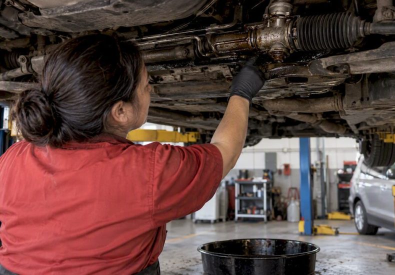 Technician inspecting leaking steering rack