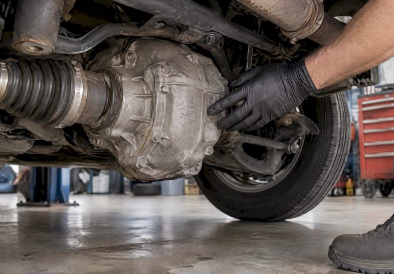 Technician inspecting vehicle rear differential