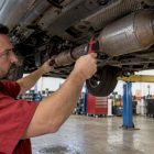 Mechanic checking a catalytic converter temperature