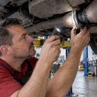Mechanic inspecting a soot-darkened exhaust flange